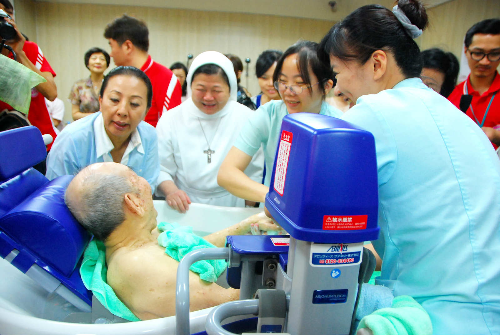 對失能長者而言,很難得能享受到一次全身沐浴的服務。圖左立者為嘉義縣長張花冠到聖馬爾定醫院護理之家探視老人。(攝影/陳俊廷)