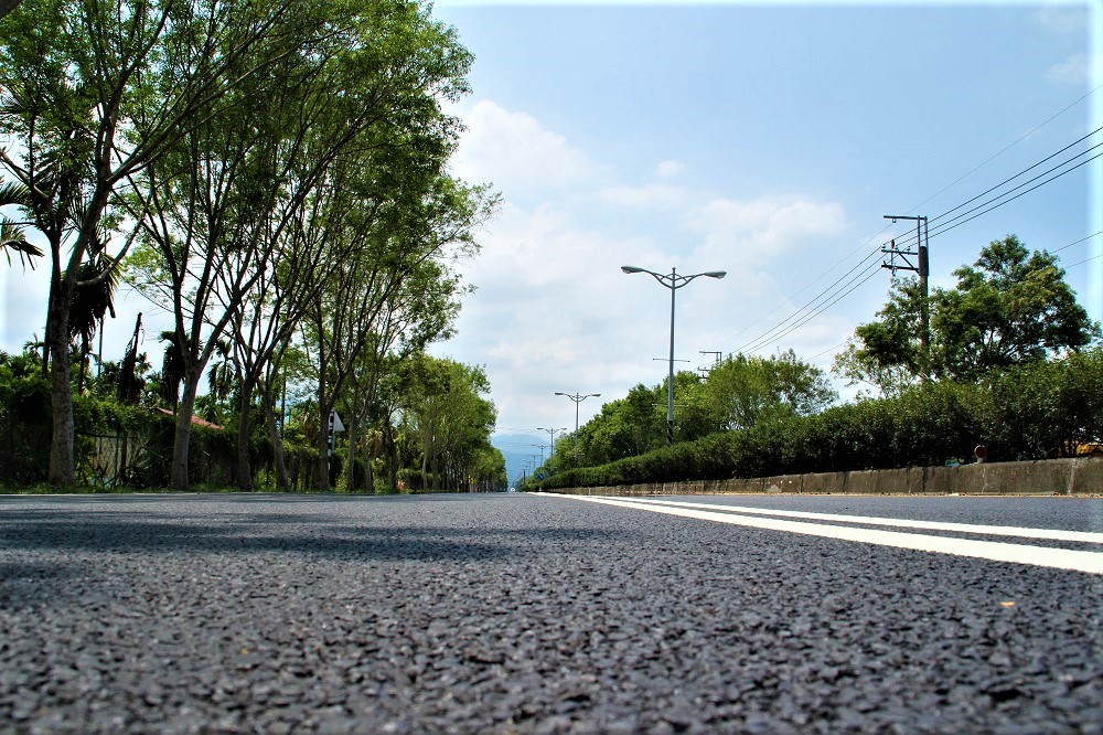 屏東科技大學前的科大路，路面凹陷不平，造成學生交通安全疑慮，且每雨必淹成河，縣政府耗資新台幣1億8900萬元完成全國最長的全透水鋪面道路。(圖/屏東縣府)