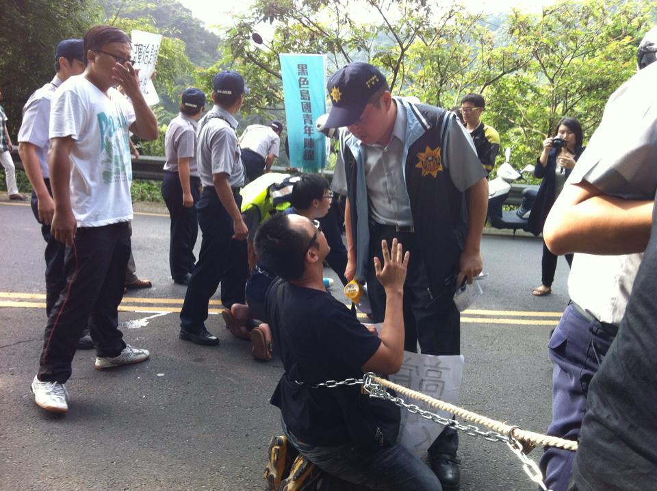 2014年中國國台辦主任張志軍來台時，太陽花學運成員魏揚等人以鐵鍊綁身欲攔阻車隊。圖／翻攝自「黑色島國青年陣線」臉書 