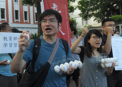 數十名學生、勞團代表4日在教育部大門口，舉行「反對大學假學習真勞動」聯合行動記者會，學生拿著布條與雞蛋呼口號表達反對訴求。（中央社）20160704