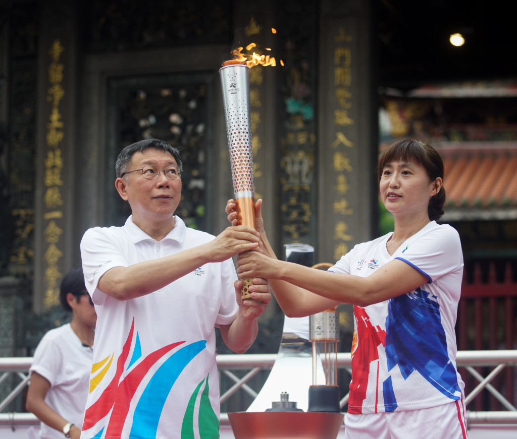 台北市長柯文哲16日出席在萬華龍山寺舉行的2017台北世大運聖火傳遞--台北舊城路線起跑儀式，並將聖火交給曾為台灣拿下第一面世大運金牌的風速女王王惠珍。圖／張良一