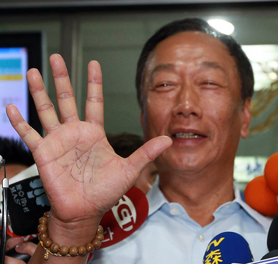 鴻海董事長郭台銘（圖）控告名嘴周玉蔻指他捐新台幣3億元政治獻金，他手心寫了兩個「忍」字出庭。（資料照片，中央社）20150821