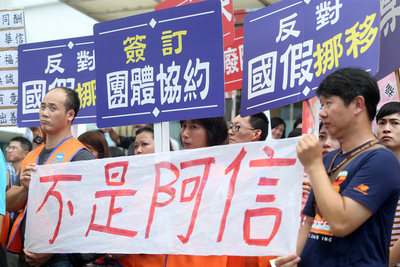 100多位華信航空工會會員12日下午到華信航空大門拉布條抗議，高喊「我是華信，不是阿信」。（中央社）