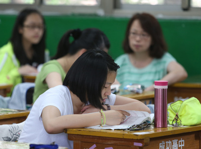 十二年國教首屆國中教育會考17、18日2天舉行，全國有27萬1205名考生應試。考生把握休息時間準備下一科考試科目，家長在旁陪伴。圖:中央社