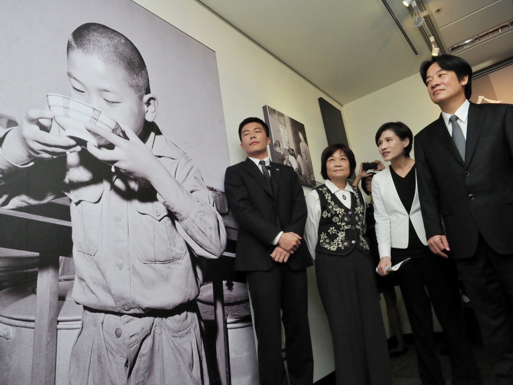 行政院長賴清德參觀展覽「生活•話當年-1950、1960年代國家影像特展」，左方展出是當時小學生喝牛奶的照片。圖／張家銘