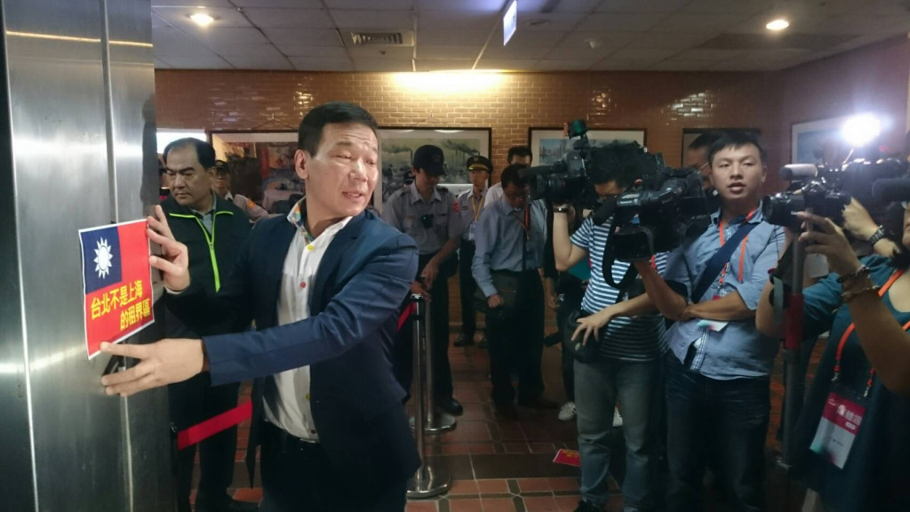 台北市議員鍾小平認為北市長柯文哲對上海市常委沙海林是「第一對第五」，是喪權辱「市」，到歡迎晚宴門口張貼國旗抗議。圖／何豪毅攝