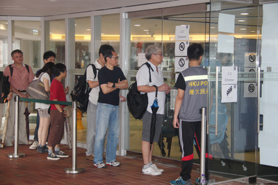 由香港「占中」運動發起的特首普選方案投票，22日起進行實體票站投票，圖為設在香港大學的票站，有人輪候投票。圖：中央社