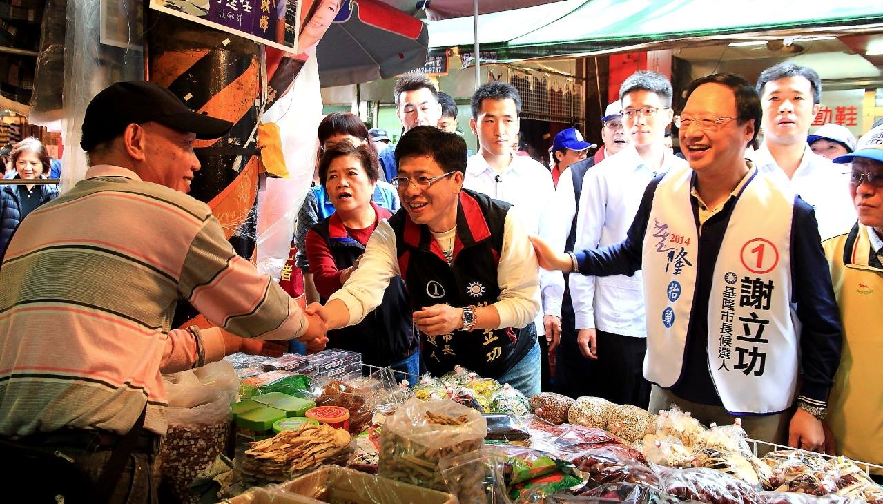 行政院長江宜樺陪同謝立功在基隆市場內掃街拜票，不料遭人嗆聲：「嫌我們是二等公民、二等城市，幹嘛回來？」（翻攝自謝立功臉書）