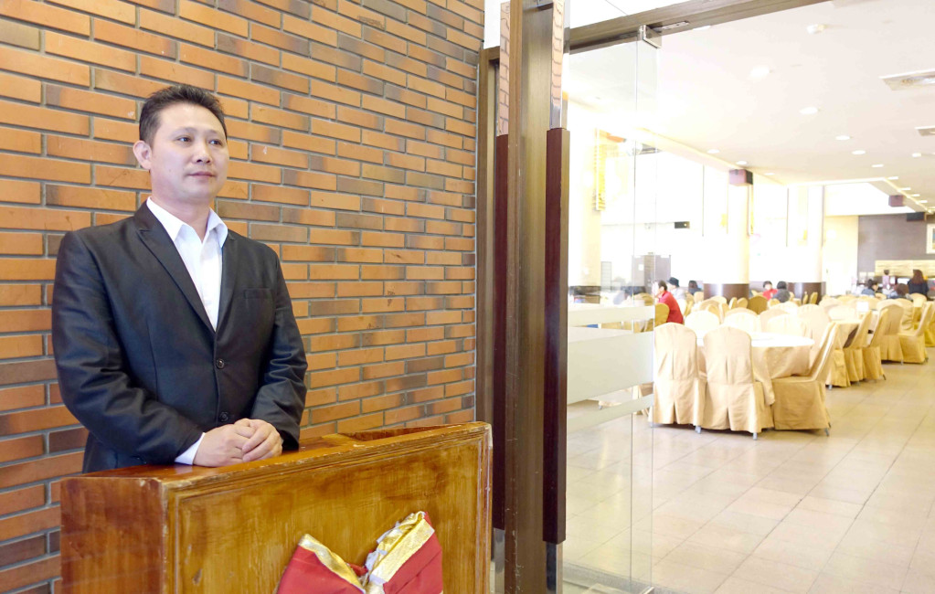 雖然已是餐飲總監,陳揚仁每天早上六點半就站在餐廳門口,服務每位客人。記者蔡育豪攝影