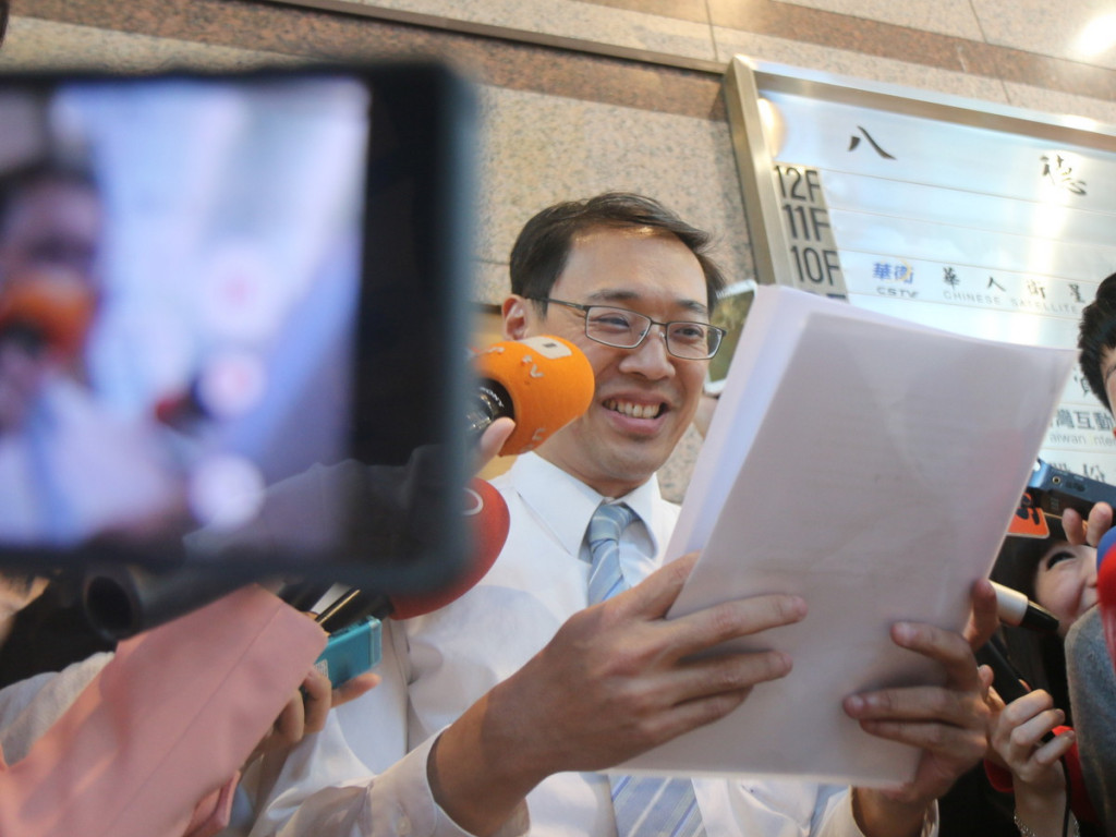 國民黨中常會照案通過提案臨時全代會「換柱」,黨發言人楊偉中一時情急唸錯稿子,堆了笑臉要求重錄一遍。(記者何豪毅攝)20151014