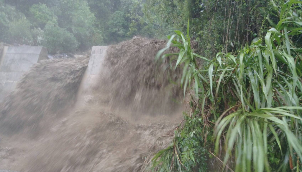 梅雨鋒面今天狂襲中部地區，山城南投爆發土石流，臨海的雲林則是淹大水。(圖為南投力行產業道路土石流滾滾而下。讀者提供)