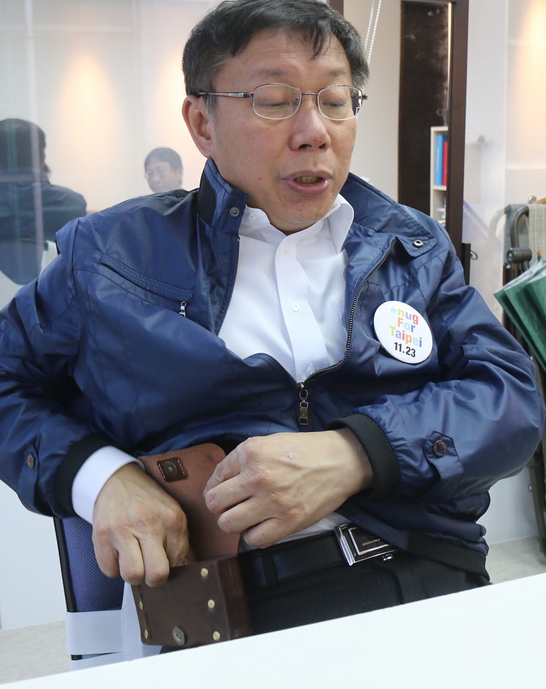 專訪柯文哲時，柯P手機響起，他順手從腰間拿出手機就與對方聊起來，好像和街坊上常看的「歐吉桑」沒兩樣喔？！（記者何豪毅攝）