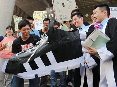 學運領袖陳為廷（前左）去年朝苗栗縣長劉政鴻丟鞋案，遭判處罰金新台幣1萬元並沒入運動鞋。陳為廷宣判後主張「請法院還我鞋」，現場聲援民眾並送上巨型球鞋替他加油打氣。（中央社檔案照）