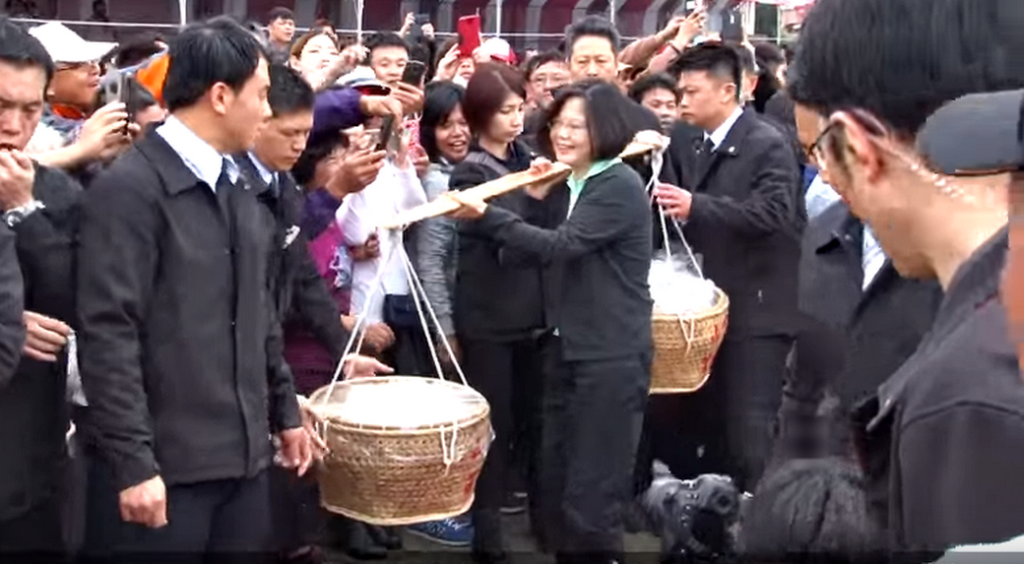 蔡英文挑肩挑飯擔進場參與雲林褒忠馬鳴山鎮安宮「吃飯擔文化節」(記者陳俊廷翻攝)