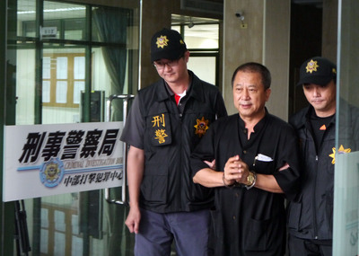 現任嘉義縣議員陳保仁（中）涉嫌於去年底當選謝票時，率眾毆打對手的支持民眾，26日遭警方拘提到案，並依殺人未遂罪移送法辦。（中央社）20150526