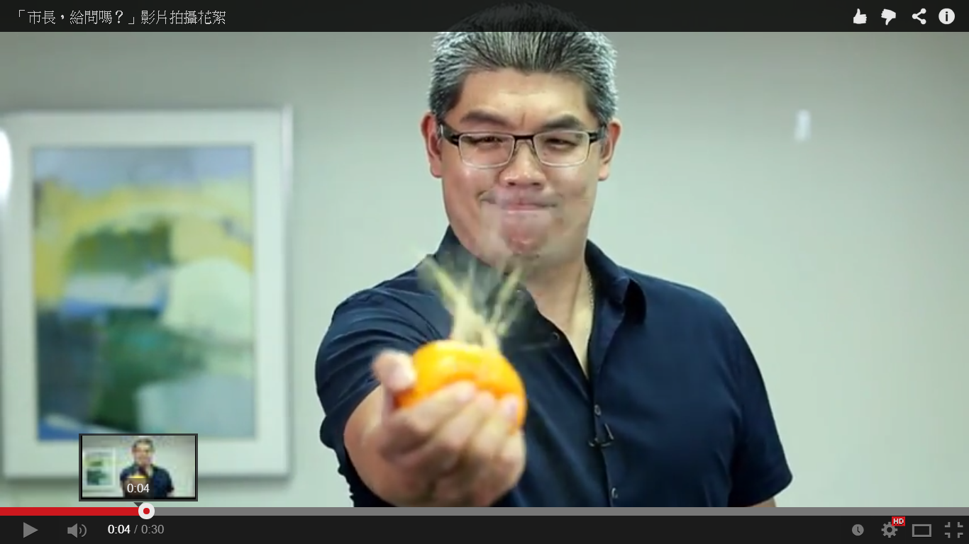 連勝文單手捏爆橘子，象徵將逆襲。（翻攝自影片）