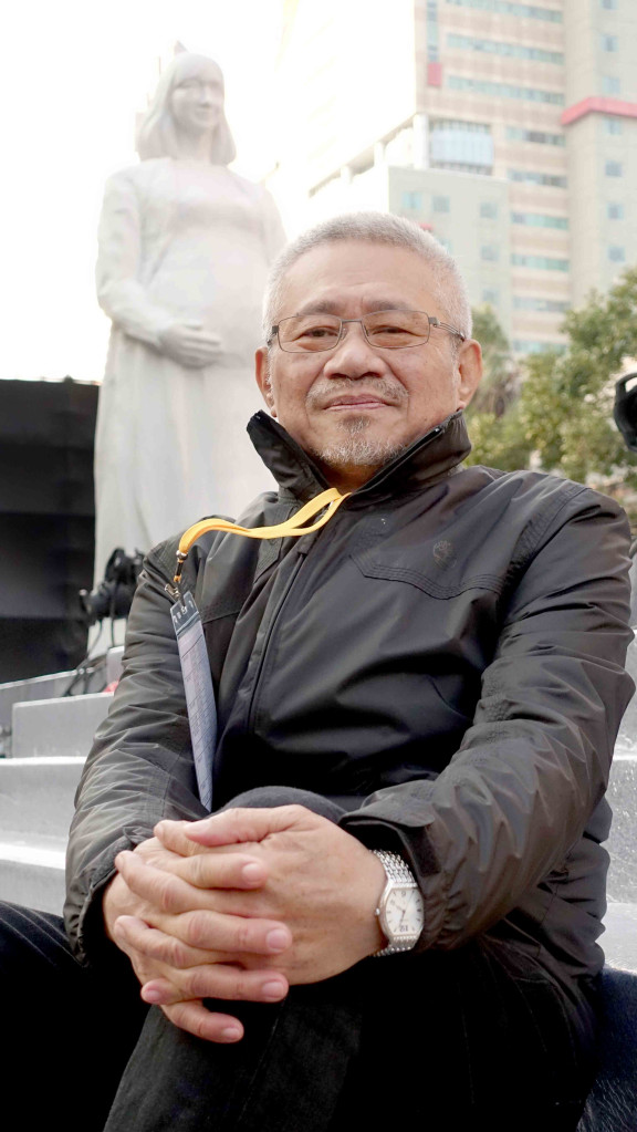 李良仁與巨型雕像。記者蔡育豪攝影