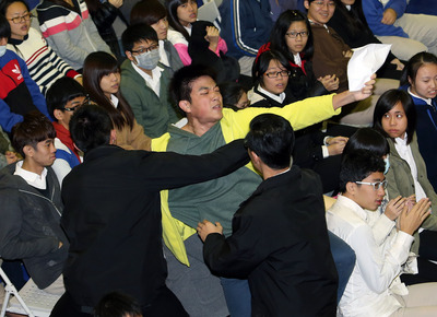 總統馬英九20日出席「台北商業大學97週年校慶活動」，學生朱士晉（中黃外套者）衝上前陳情，高喊「北商需要校地」，遭維安人員架離。（中央社）