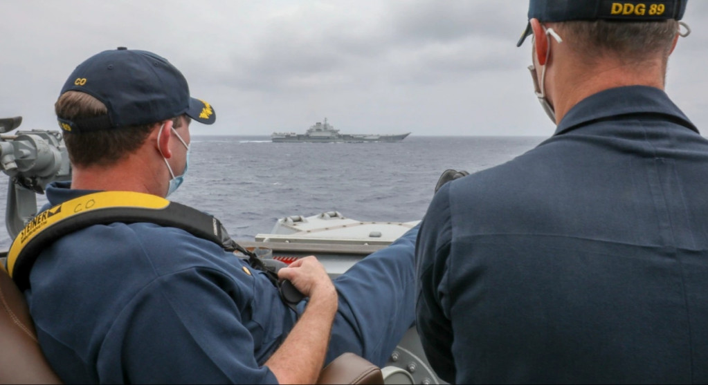 美國海軍馬斯廷號驅逐艦的艦長羅伯特·布裡格斯中校（Robert J Briggs）與副艦長理查·斯萊中校（Richard D Slye）2021年4月4日在菲律賓海域正在導航室外監視中國航母遼寧號。這張由美軍釋出的照片佔盡國際媒體版面，台灣媒體連續頭條報導，政論節目也連日討論美軍面對中共航母的「氣定神閒」。圖／美國海軍提供