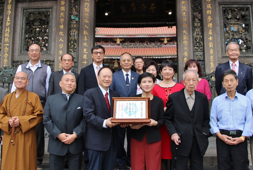 文化部長鄭麗君（前排右3）頒發國定古蹟指定證書給予艋舺龍山寺，由台北市艋舺龍山寺董事長黃書瑋（前排右4）代表接受證書。圖／文化部提供