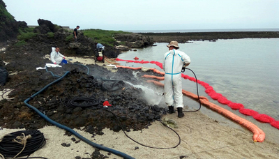 綠島油污事件，台東地檢署分析資料後，認為涉嫌海洋污染防治法，分案偵辦；不過，涉嫌貨輪已經航向第三國。圖為相關人員進行海岸油污清理作業。圖／台東縣環保局提供