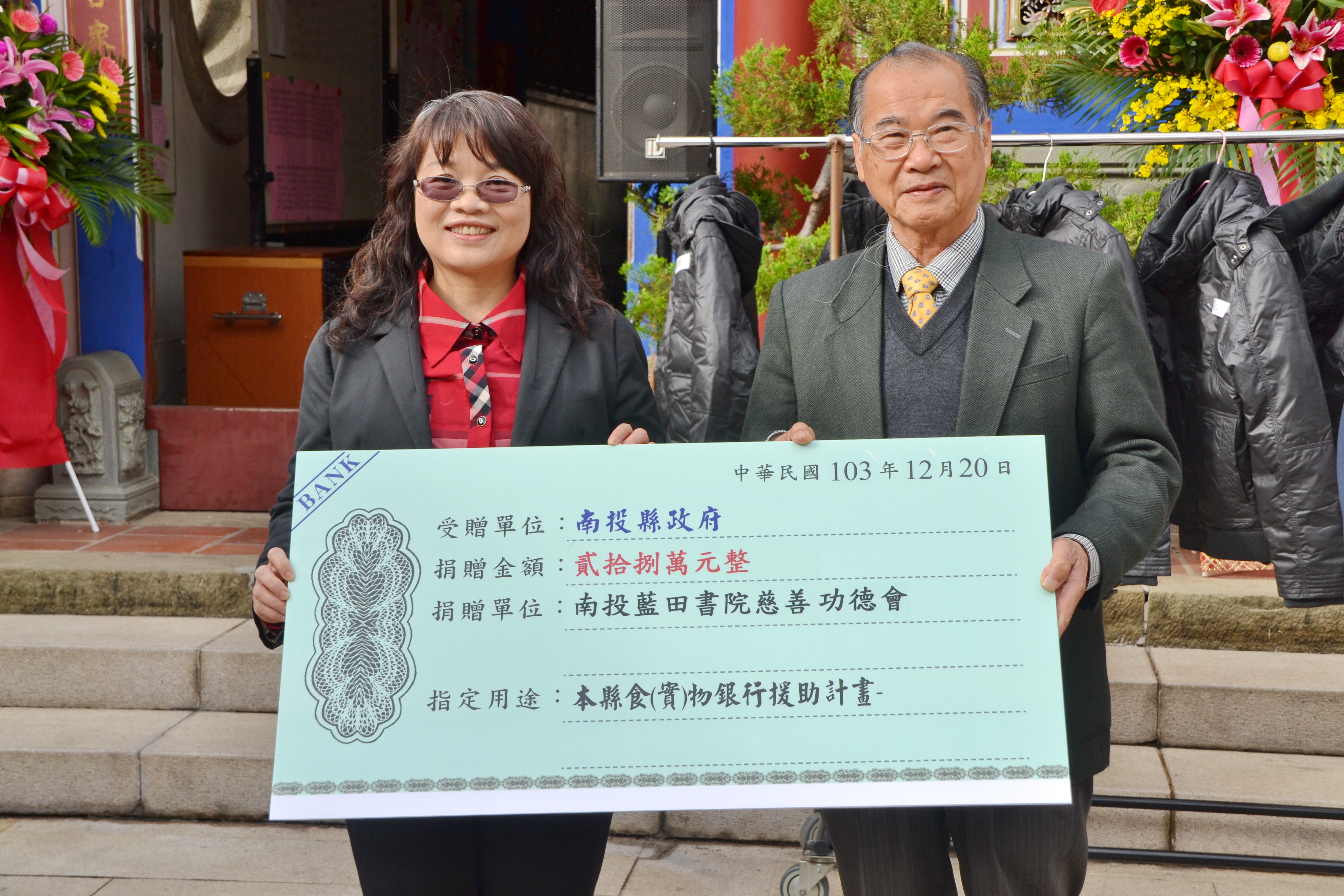藍田書院為幫助南投縣低收入戶過冬，舉辦103年寒冬送暖活動，發送餐食兌換券共計28萬元、皇穹陵紀念花園也捐贈250件冬衣，縣府社會處長吳燕玲（左）代表接受。（記者石振賢攝）