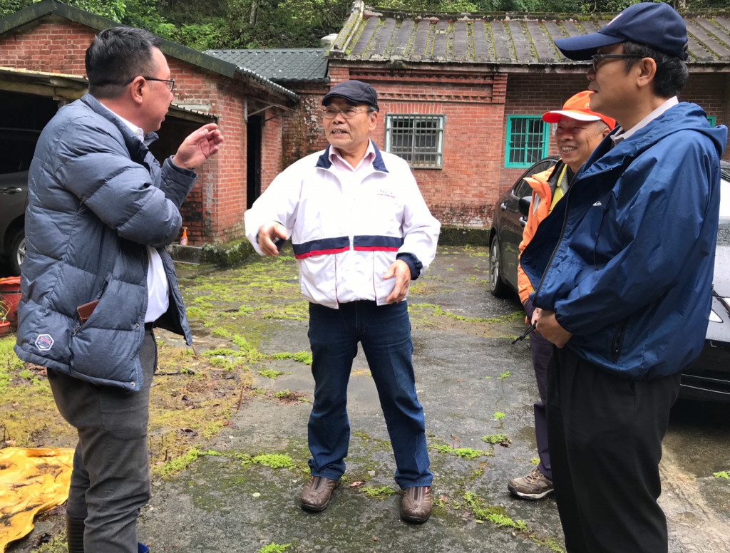 邱明男先生（中）在自宅前熱情為大家解說。圖／唐植梅