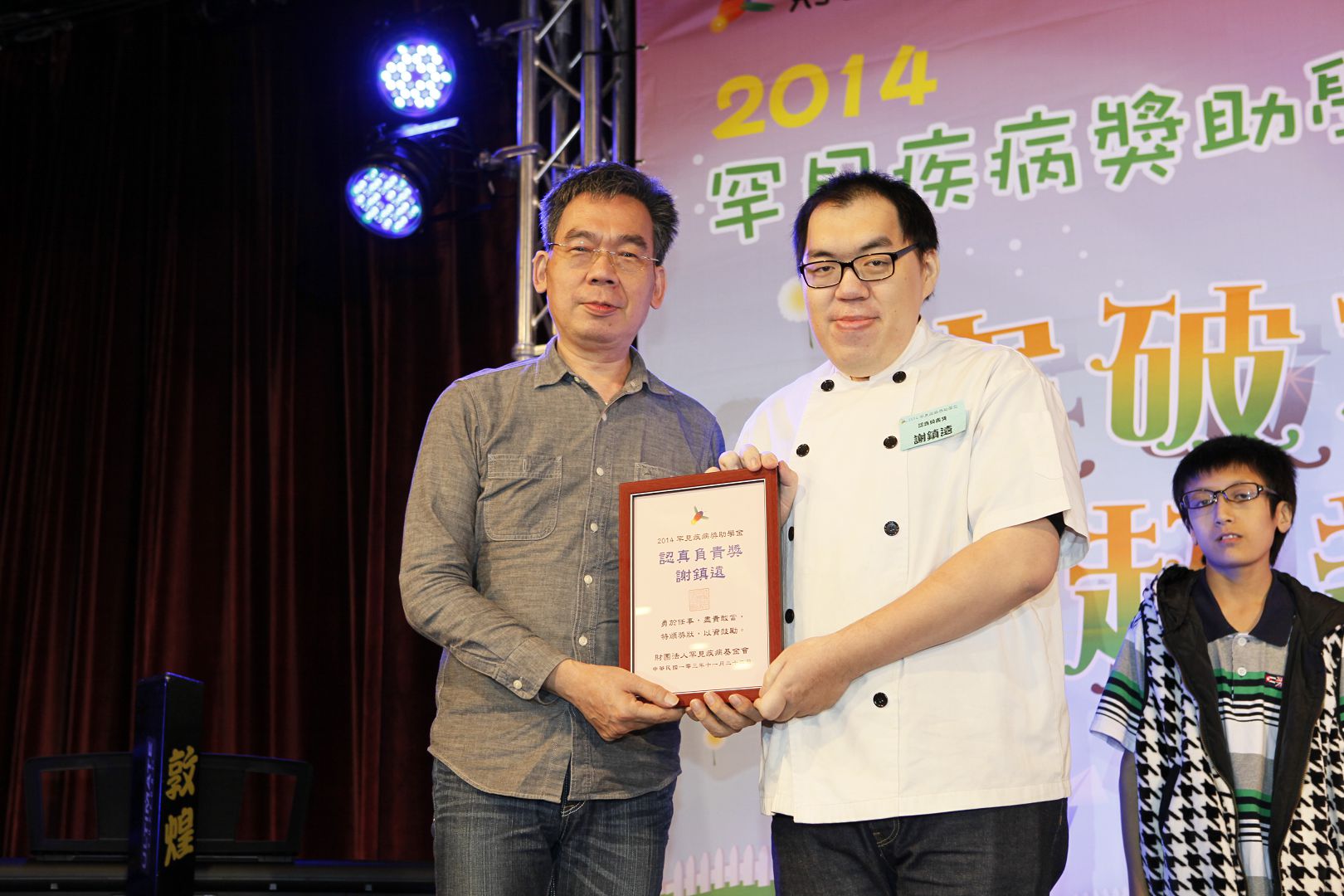 疾病所帶來的困擾並未能侷限謝鎮遠(右)對於烘焙的熱情,讓他獲得「2014罕病獎助學金認真負責獎學金」的肯定。除了持續在職進修外,鎮遠每天第一個到公司,最後一個離開公司,堅持敬業,用努力獲得尊敬。(圖:罕病基金會提供)