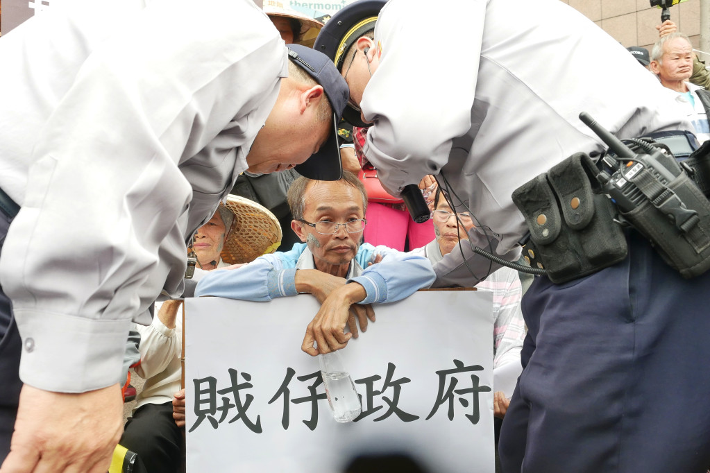 台南龍崎牛埔里長陳永和及自救會一行人，在民進黨中央黨部前抗議遭警方驅離。圖／張家銘