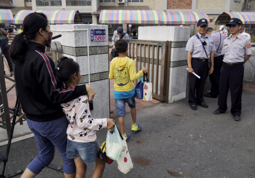 雲林縣政府為了不讓學生曝露在可能污染下，決定把許厝分校師生安置到校本部橋頭國小與豐榮國小，但學生與家長不願安置，今天全校9成9學生全到許厝分校，迎接學生開學的則是成排的警察與帳棚，形成有學生、沒教室也沒老師的窘境。（張良一 攝）