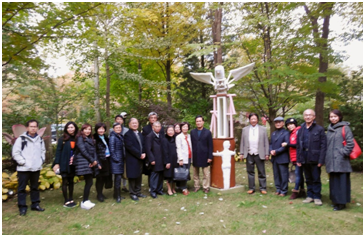 醫師畫家施哲三於2018年10月25日，在其芝加哥海嵐公園海嵐美術舘舉行宴會，歡迎國際扶輪社――阿其柯藍夫會員，合影於「世界和平」雕塑合影。圖／陳雅琳提供