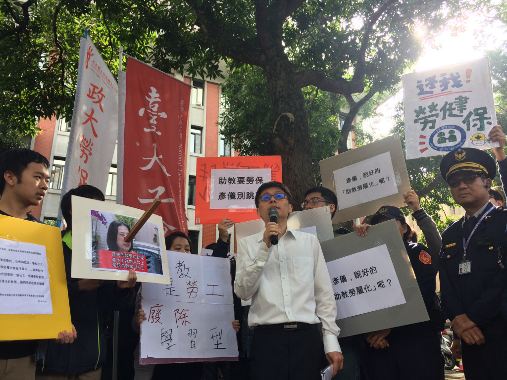 教育部高教司吳志偉出面回應學生針對大學中學習型助理勞僱化的訴求，後方學生高舉「給我勞健保」的標語，由於教育部表示目前還在研議中尚無定論，雙方對話無共識。圖／李秉芳