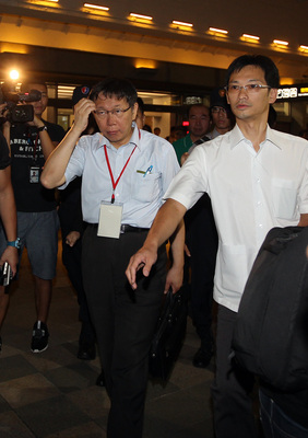 台北市長柯文哲(前左)19日晚間結束上海雙城論壇行程搭機返台,在台北松山機場表示,上海市有很多優點,看完以後要想一下,真正的感想要消化一下。(中央社資料照片)