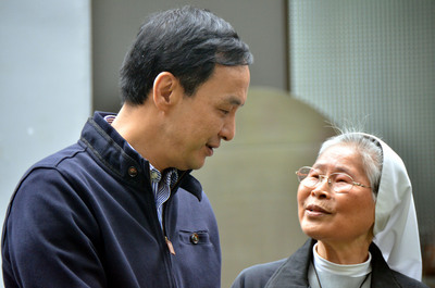 國民黨總統候選人朱立倫（左），28日上午到台東關心弱勢孩童，和國中老師、潘修女（右）相見歡。（中央社）