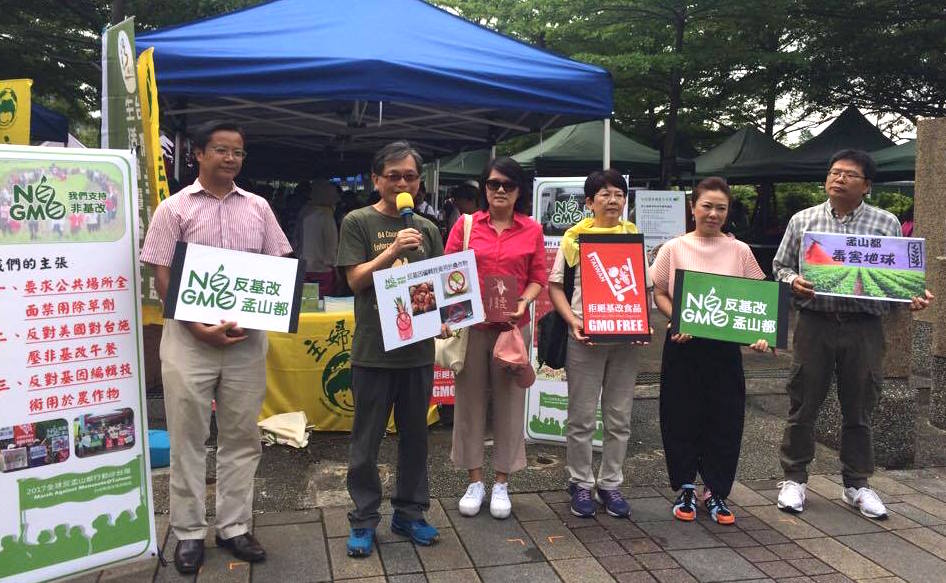 數個民間團體在公館水岸花園農夫市集前召開記者會，呼籲消費者透過團結力量，共同要求政府不能因為貿易談判壓力，讓非基改食品進到校園營養午餐。圖／李秉芳