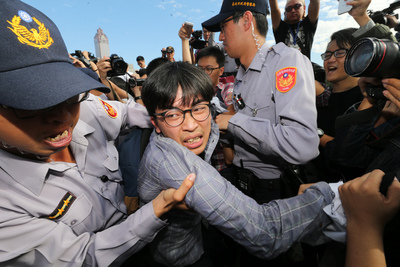 青年團體不滿政府修法砍假，18日早上無預警前往總統官邸抗議，後轉往總統府，和現場警方爆發推擠衝突。圖／中央社