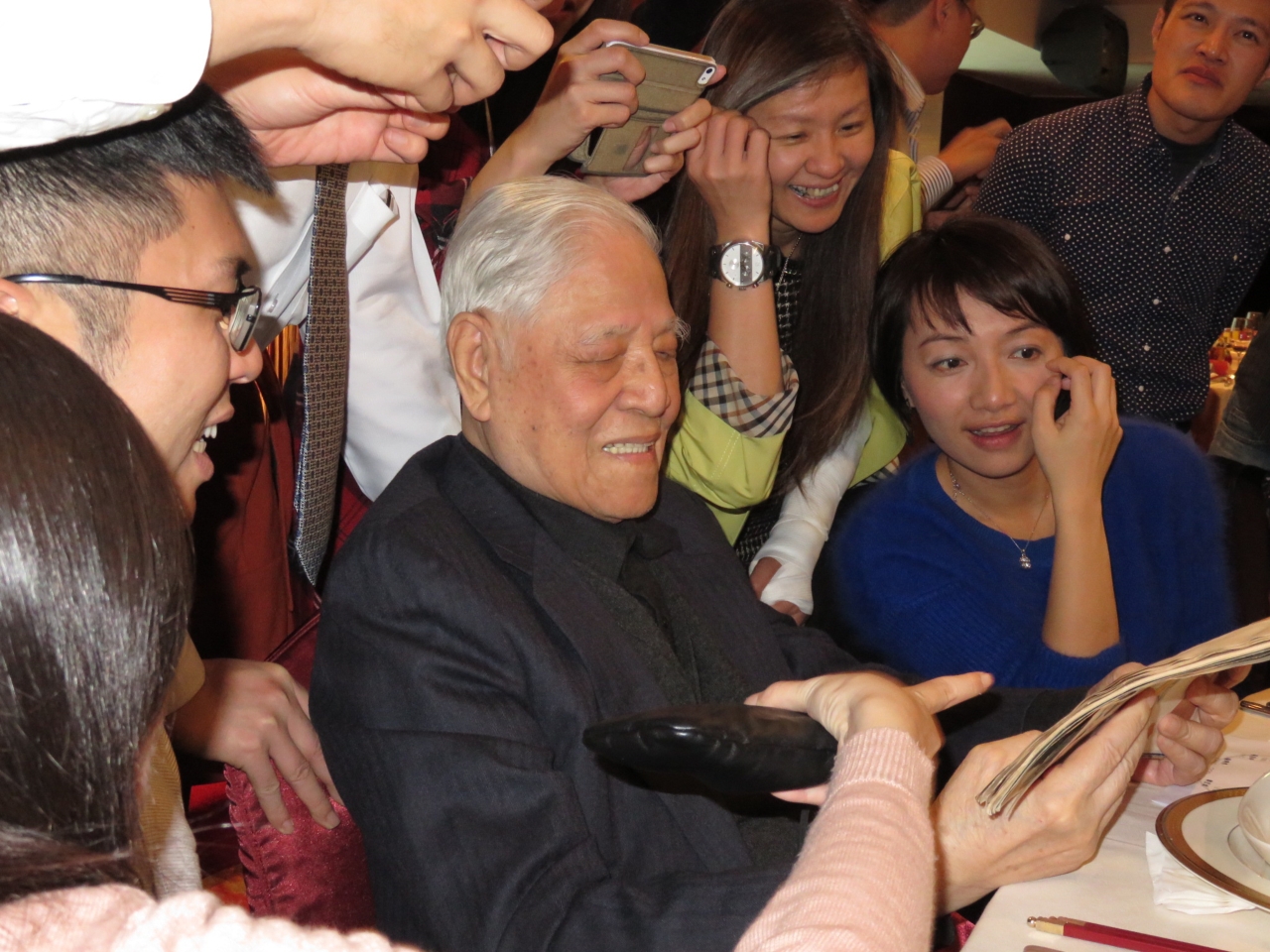 一年輕記者拿小二剪報請李登輝簽名,李笑開懷。(朱蒲青攝)