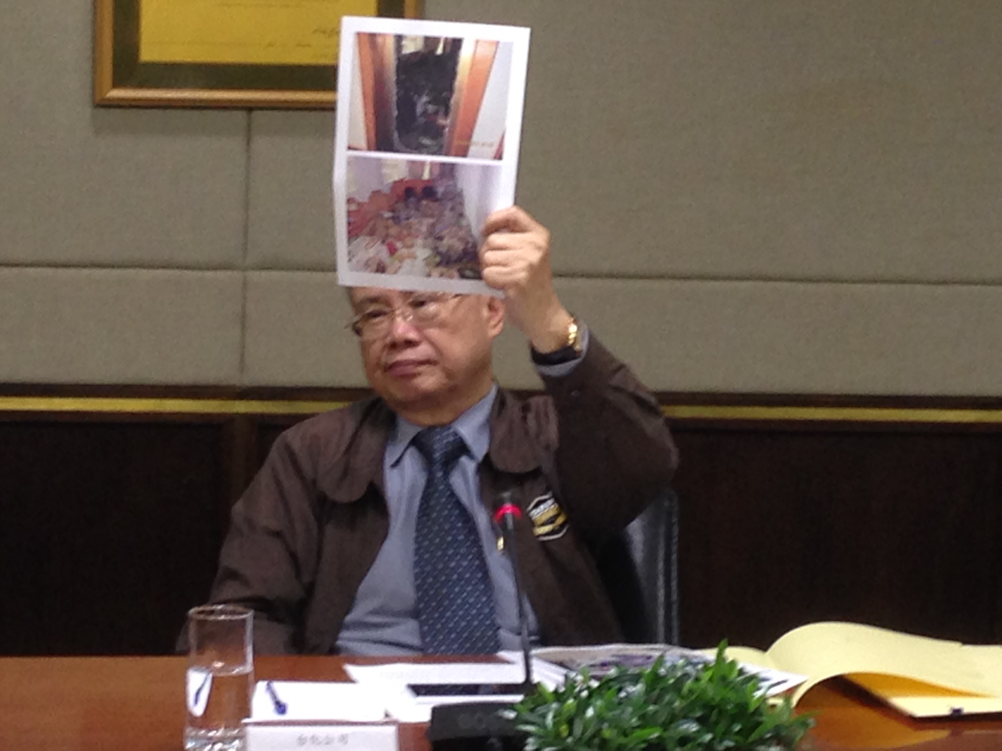 台化總經理洪福源拿出越南仁澤廠區宿舍遭砸毀照片,強烈抨擊當地民眾猶如暴民的行為。(陳文蔚攝)