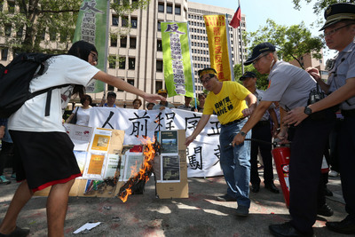 反南鐵東移全線自救聯合會21日到內政部抗議「人前程序正義、人後強闖東移」，質疑部長葉俊榮違反自己的著作《面對行政程序法》，當場焚燒葉著作。圖／中央社