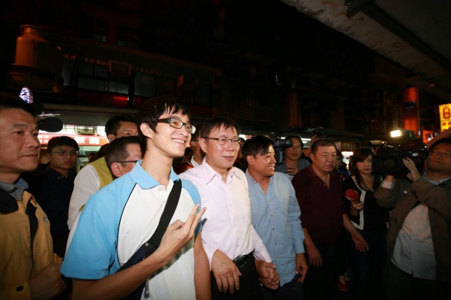 無黨籍台北市長候選人柯文哲今晚連趕兩場夜市拜票行程,雨天氣候,民眾熱情不減,年輕民眾爭相拍照留影,為了方便大家拍照,幕僚一度集合地點,一次讓民眾拍個夠。(照片來源:柯文哲辦公室提供)