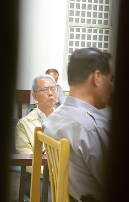 彰化地檢署16日晚間傳訊前頂新製油公司董事長魏應充（後），檢方安排魏應充走秘密通道應訊，讓在外守侯的媒體及民眾撲空。（中央社翻攝畫面）