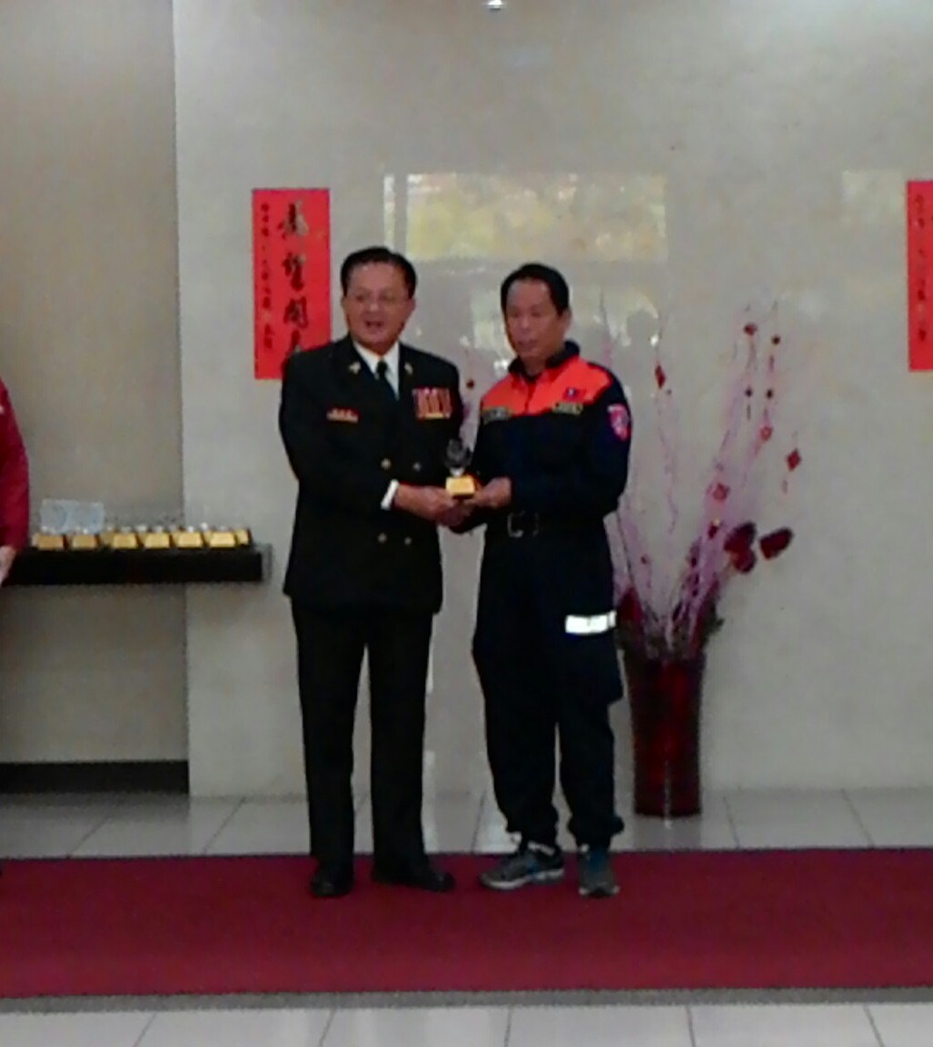 台中市消防局長蕭煥章（左）頒獎章給協勤救災勇士。（記者汪明毅攝）