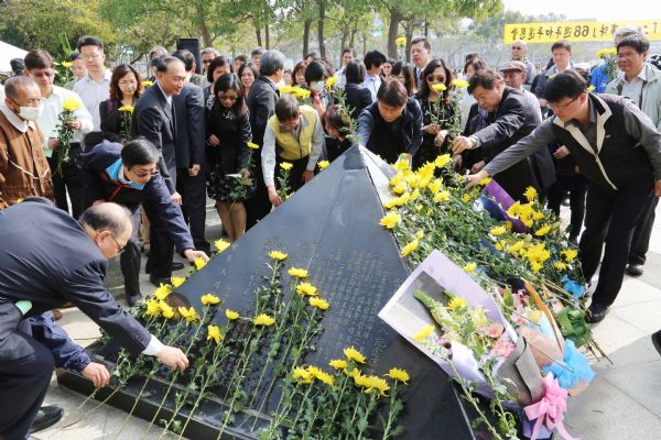 228家屬與出席者將鮮花放置於紀念碑前表達追思（照片台南市府提供）