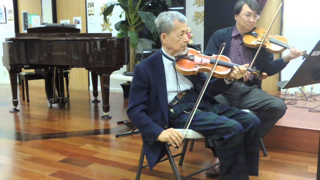 精通音樂及美術的周烒明醫師（前）熱衷繪畫及大提琴，後因健康問題由小提琴改為大提琴。圖／翻攝自 Youtube 影片〈周烒明醫師 & Johnny Chiou 合奏台灣歌謠 "阮不知啦"〉