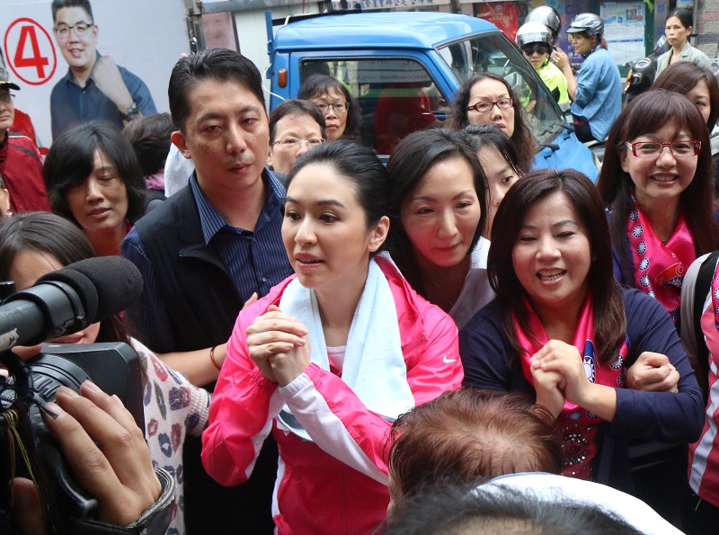 國民黨台北市長候選人連勝文妻子蔡依珊代夫出征，赴湖光市場拜票，擠不進的攤位就拱手拜票。（記者何豪毅攝）
