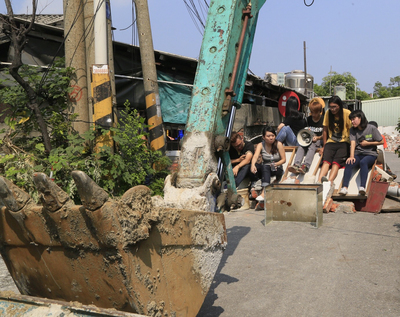 高市府1日動員數百警力配合農業局拆遷牴觸果菜市場住戶，引發居民抗爭，除了牴觸戶還有數十名年輕人聲援，指高市府罔顧人民權益。圖／中央社