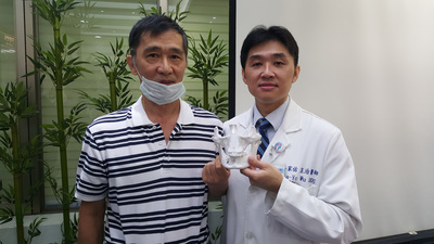 台北醫學大學附設醫院口腔外科主治醫師吳家佑（右）首度運用3D列印技術進行平先生（左）口腔癌切除與重建手術，手術精確性提高，也縮短手術時間，減少病患負擔。(中央社資料照片)