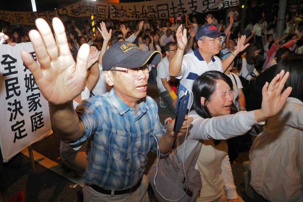 反同婚群眾得知司法委員會決議修法前先召開公聽會後，集體向上帝禱告感謝勝利。圖/張家銘