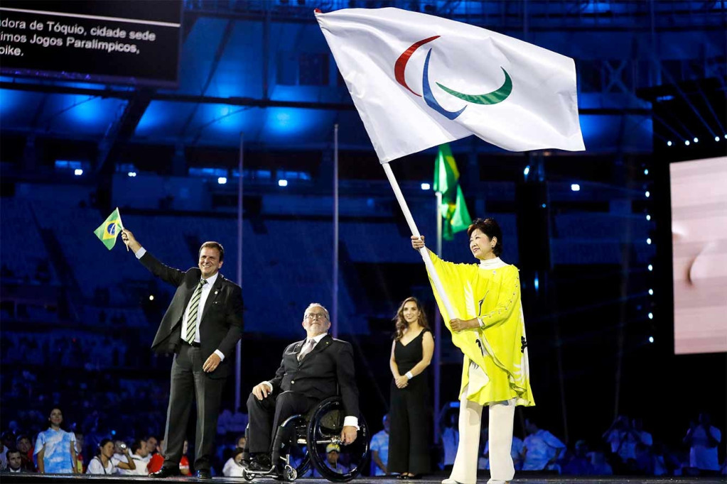 當國際帕奧會（IPC）英國籍主席克雷文（Philip Craven）將會旗交給下屆2020年帕奧會主辦城市~東京都知事小池百合子的手中，象徵這屆里約奧運相關賽事都已經完成，下次2020東京見。圖/取材自東京奧運官網https://tokyo2020.jp/jp/