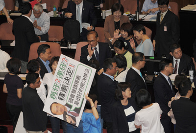立法院30日處理司法院人事同意權，民進黨立委一早就進入議場守護著主席台，國民黨立委舉看板呼口號表達反對訴求。圖／中央社